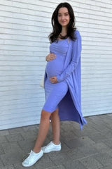 woman wearing a light purple maternity dress with a long cardigan and holding her baby bump