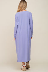 woman wearing a long lavender maternity dress with ribbed texture and long sleeves, view from the back