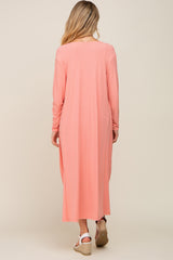 woman wearing a light pink long sleeve maternity dress with a ribbed texture, seen from the back