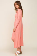 woman wearing a long peach ribbed cardigan and matching dress with white sandals