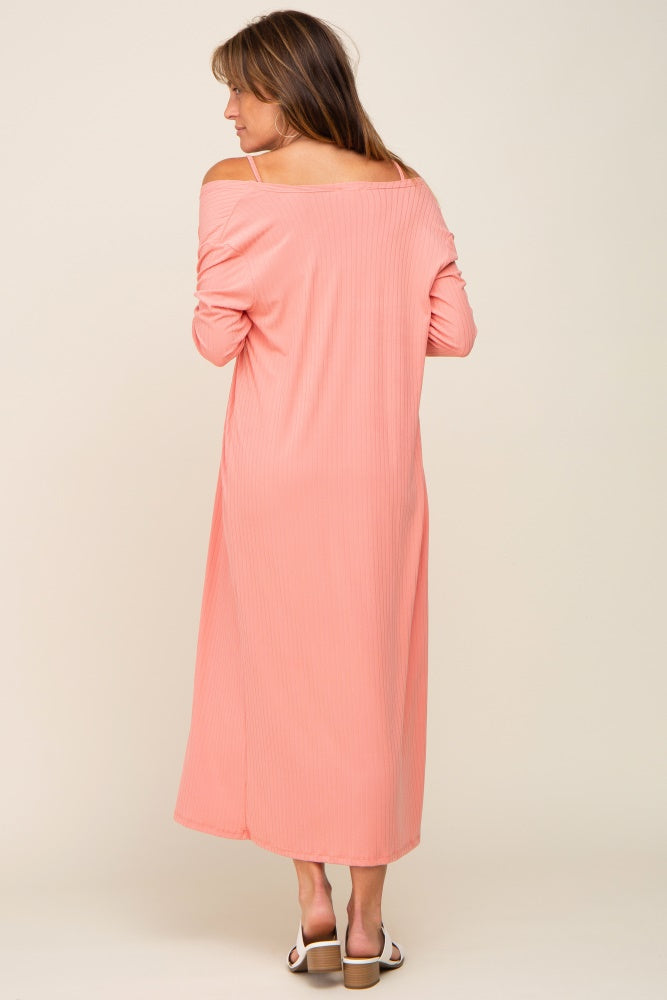 woman wearing a pink off-shoulder maxi dress with long sleeves, seen from the back