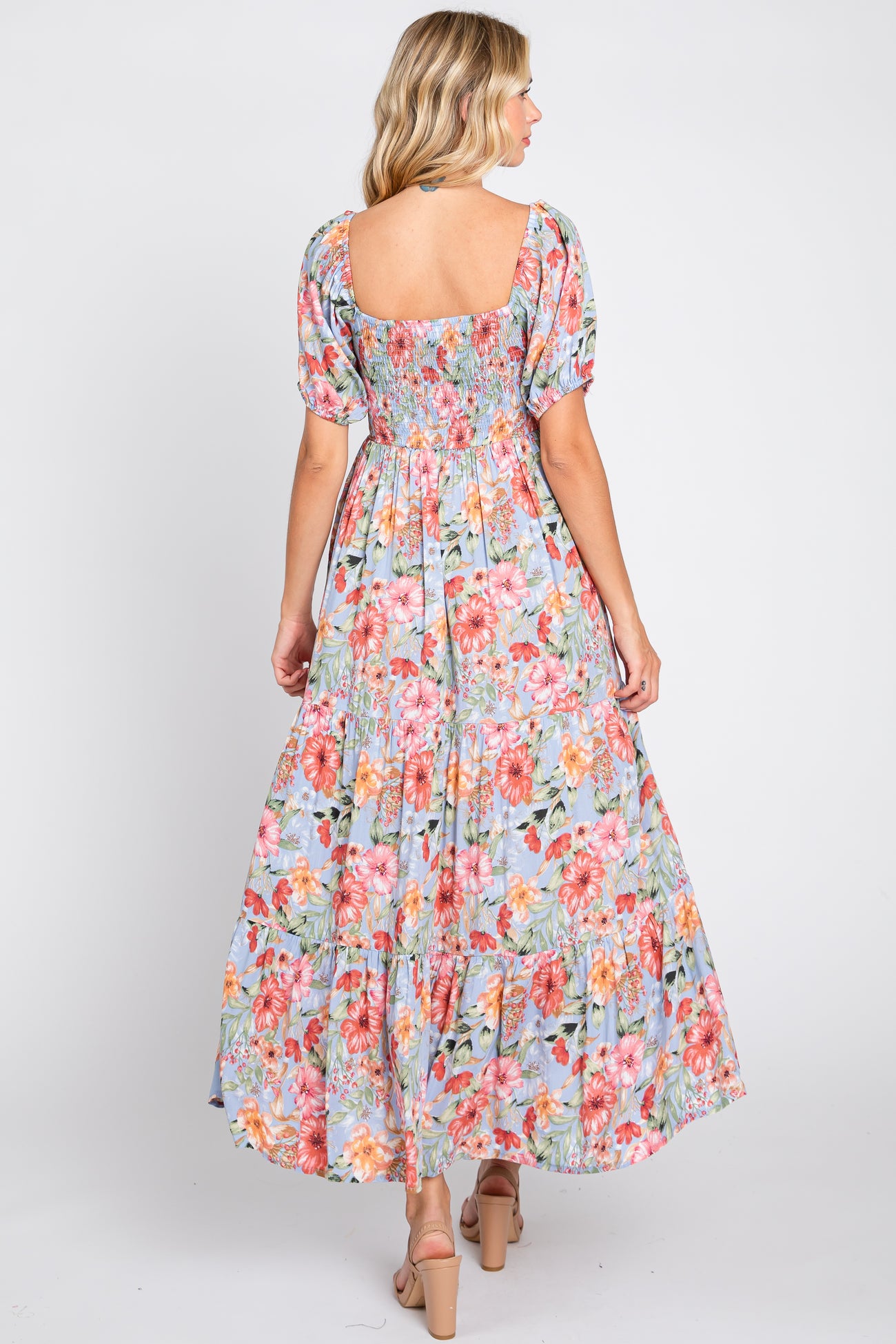 woman wearing a floral maxi dress with puff sleeves and a smocked bodice, showing the back view