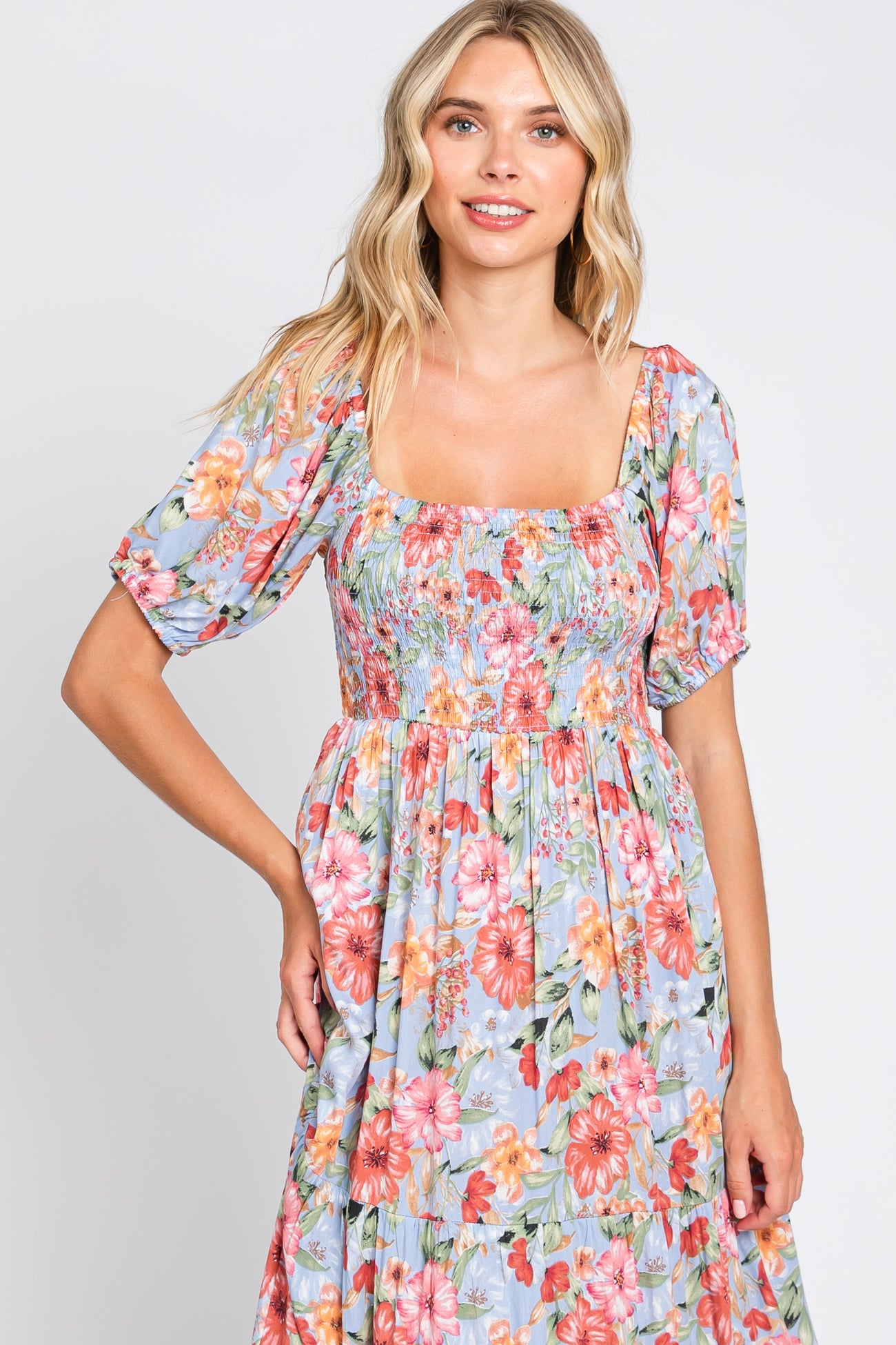 woman wearing a floral print smocked maxi dress with puff sleeves and a square neckline