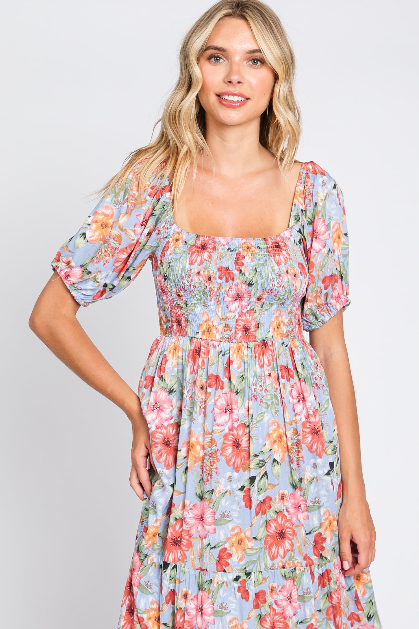 woman wearing a floral print smocked maxi dress with puff sleeves and a square neckline