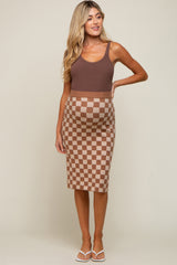 Pregnant woman wearing a brown tank top and a tan and brown checkered maternity midi skirt