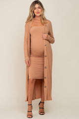 woman wearing a camel ribbed maternity dress with a matching long cardigan and showing her pregnant baby bump
