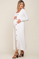 woman wearing a white long sleeve maternity dress with buttons, showcasing her baby bump