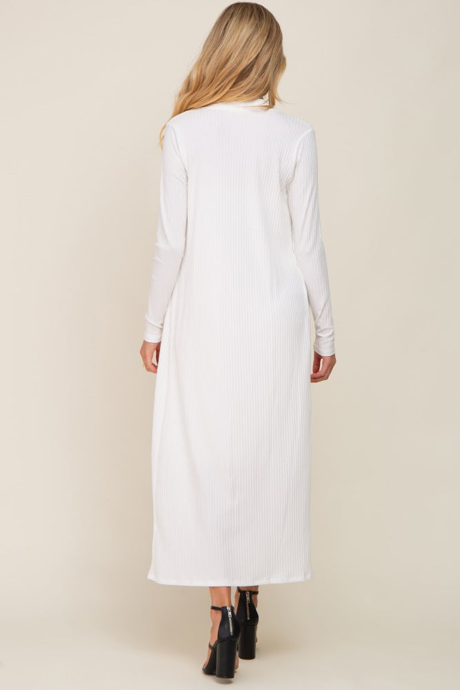 woman wearing a white long sleeve maternity dress with a ribbed texture, showing the back view
