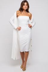 woman wearing a white strapless midi dress with a long cardigan and gold heels