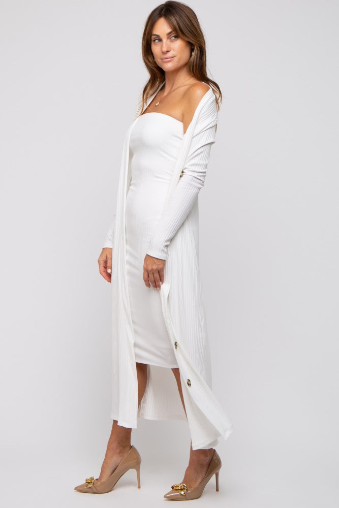 woman wearing a white ribbed midi dress with a long cardigan and high heels, showcasing a fitted silhouette