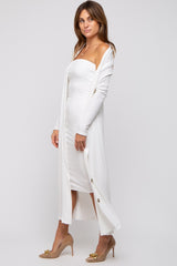 woman wearing a white ribbed midi dress with a long cardigan and high heels, showcasing a fitted silhouette