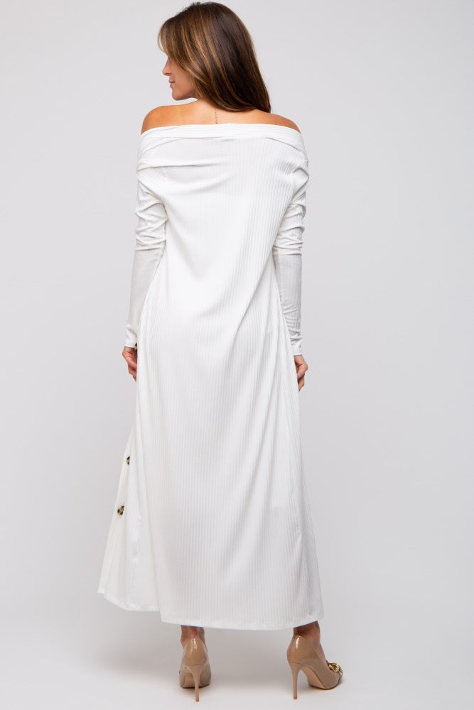 woman wearing a white off-the-shoulder maxi dress with long sleeves and button details, viewed from the back