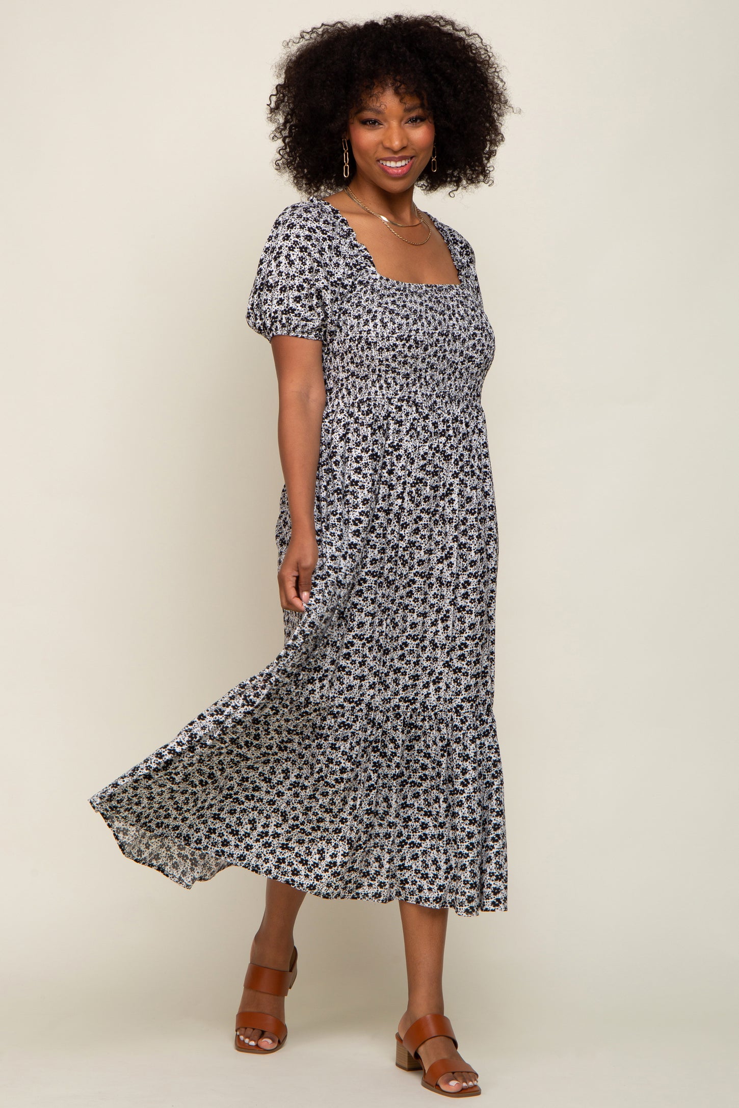 woman wearing a black and white floral print maxi dress with square neckline and short puff sleeves