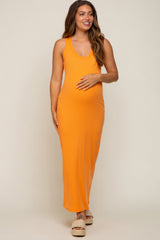 woman wearing a vibrant orange maternity maxi dress and holding her baby bump