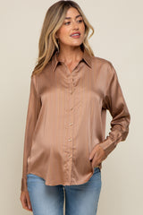 woman wearing a bronze satin button-down maternity shirt with gold pinstripes and blue jeans