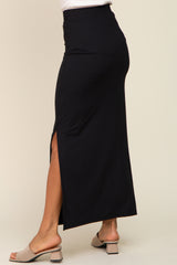 woman wearing a black ribbed maxi skirt with a side slit and paired with heeled sandals