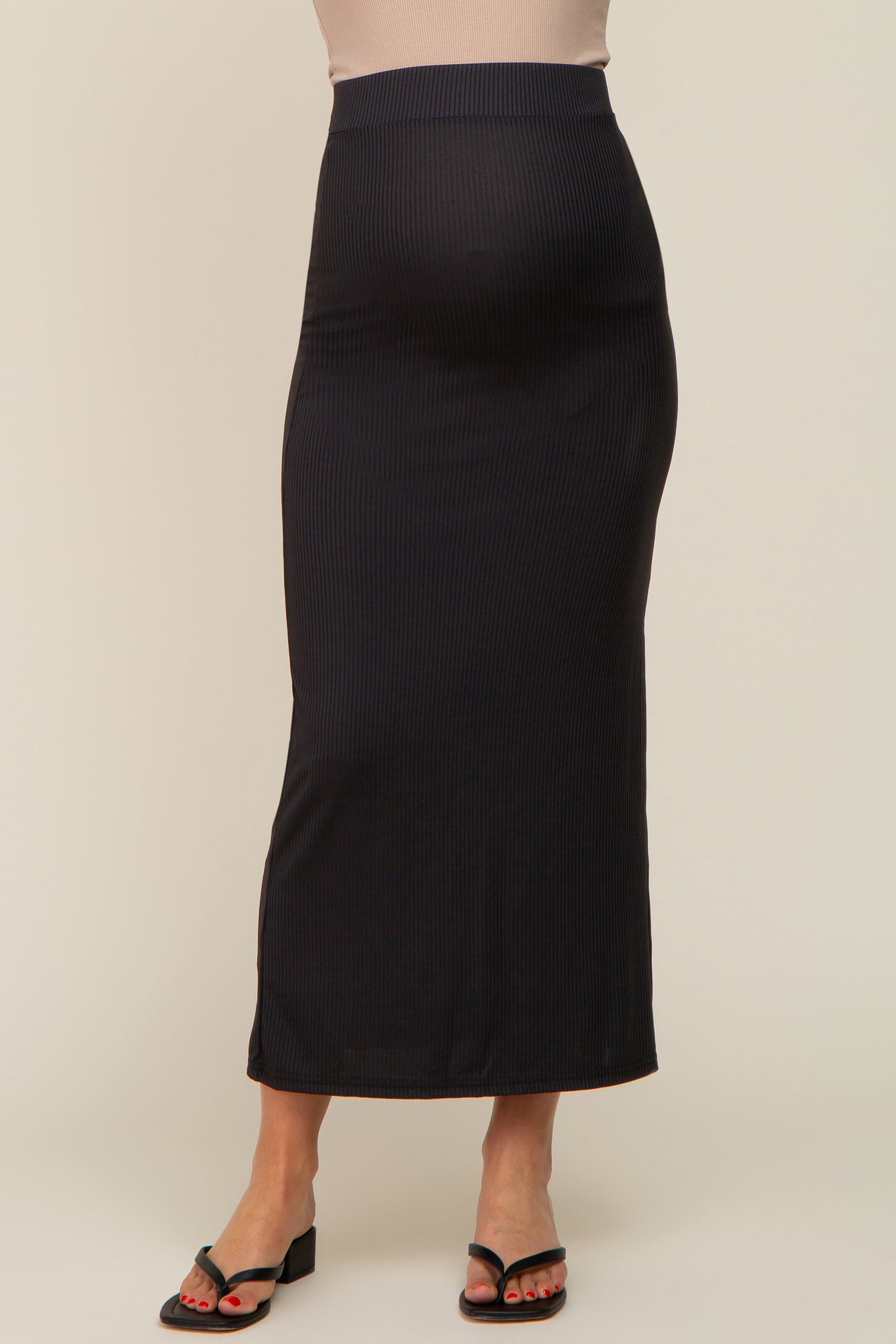 pregnant woman wearing a black ribbed maternity maxi skirt with a high waistband