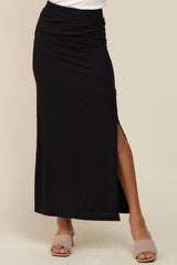 woman wearing a black ribbed maxi skirt with a side slit and neutral colored slide-on sandals