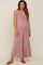 woman wearing a mauve maternity jumpsuit with a pleated front and spaghetti straps, showing her baby bump