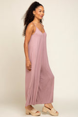 woman wearing a light mauve sleeveless maxi dress with side slits and strappy sandals