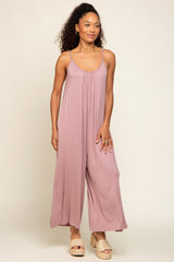 woman wearing a dusty pink sleeveless jumpsuit with wide legs and a relaxed fit