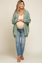 pregnant woman in sage green button down shirt and distressed maternity jeans