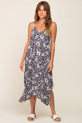 woman wearing a navy blue and white floral print midi dress with spaghetti straps and an asymmetrical hem