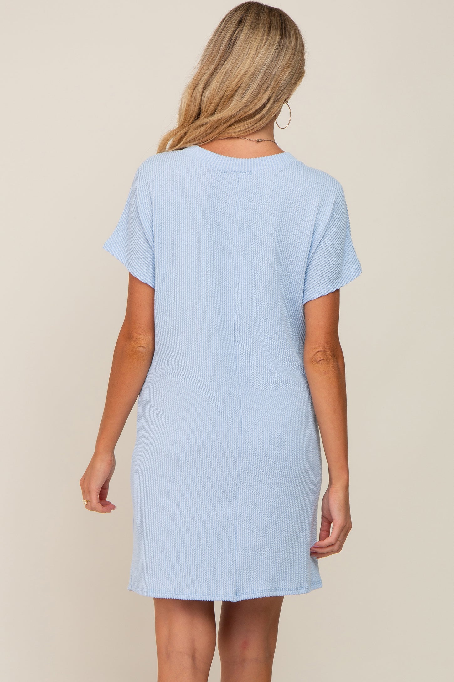 woman wearing a light blue maternity dress with short sleeves, shown from the back