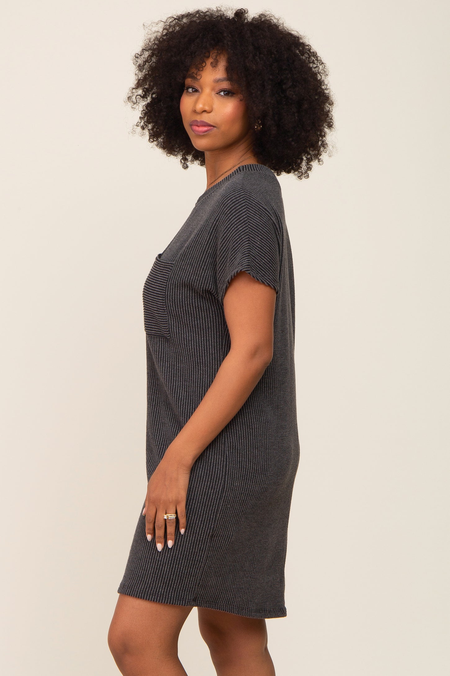 woman wearing a black striped short sleeve dress with a relaxed fit and pocket detail