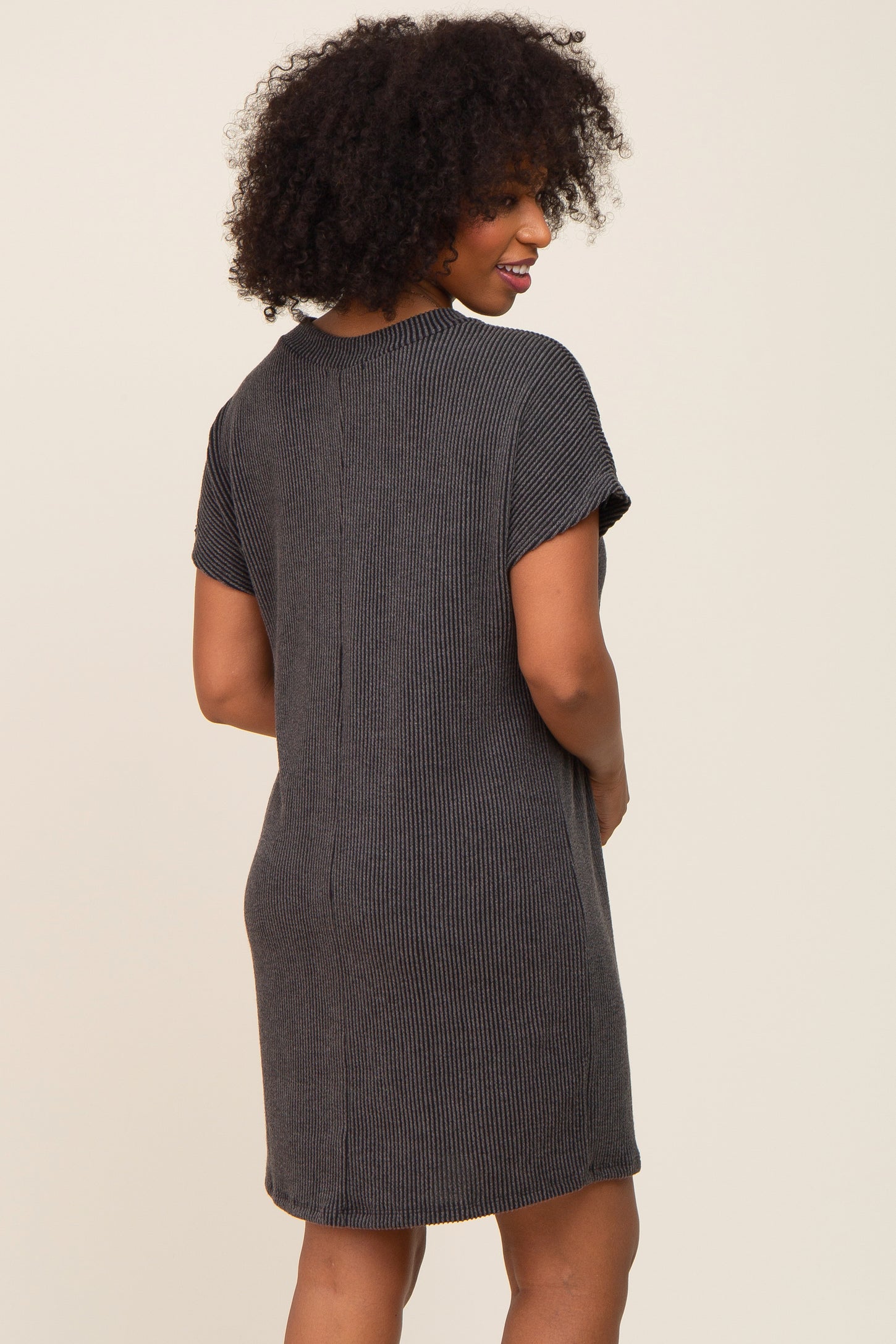 woman wearing a black and gray striped short sleeve dress, showing the back view and a relaxed fit