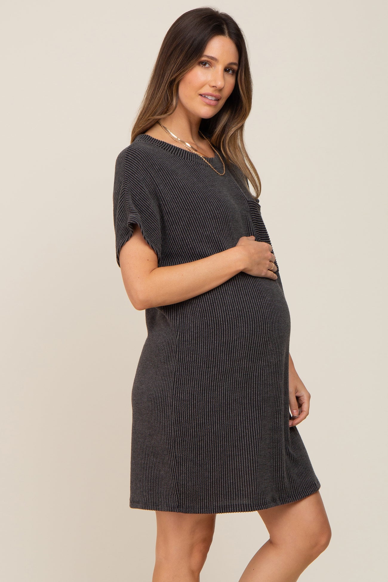 woman wearing a dark gray ribbed maternity dress with short sleeves and a visible baby bump