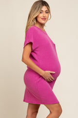 woman wearing a hot pink short sleeve maternity dress and holding her baby bump