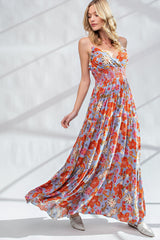 woman wearing a floral maxi dress in red and blue with a smocked bodice and flowing skirt