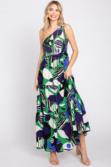Woman wearing a one-shoulder green and blue floral print maxi dress with a tiered skirt and smocked bodice