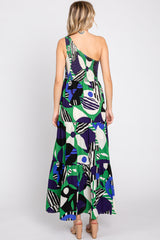 woman wearing a colorful patterned one-shoulder maxi dress with a tiered skirt and a fitted bodice