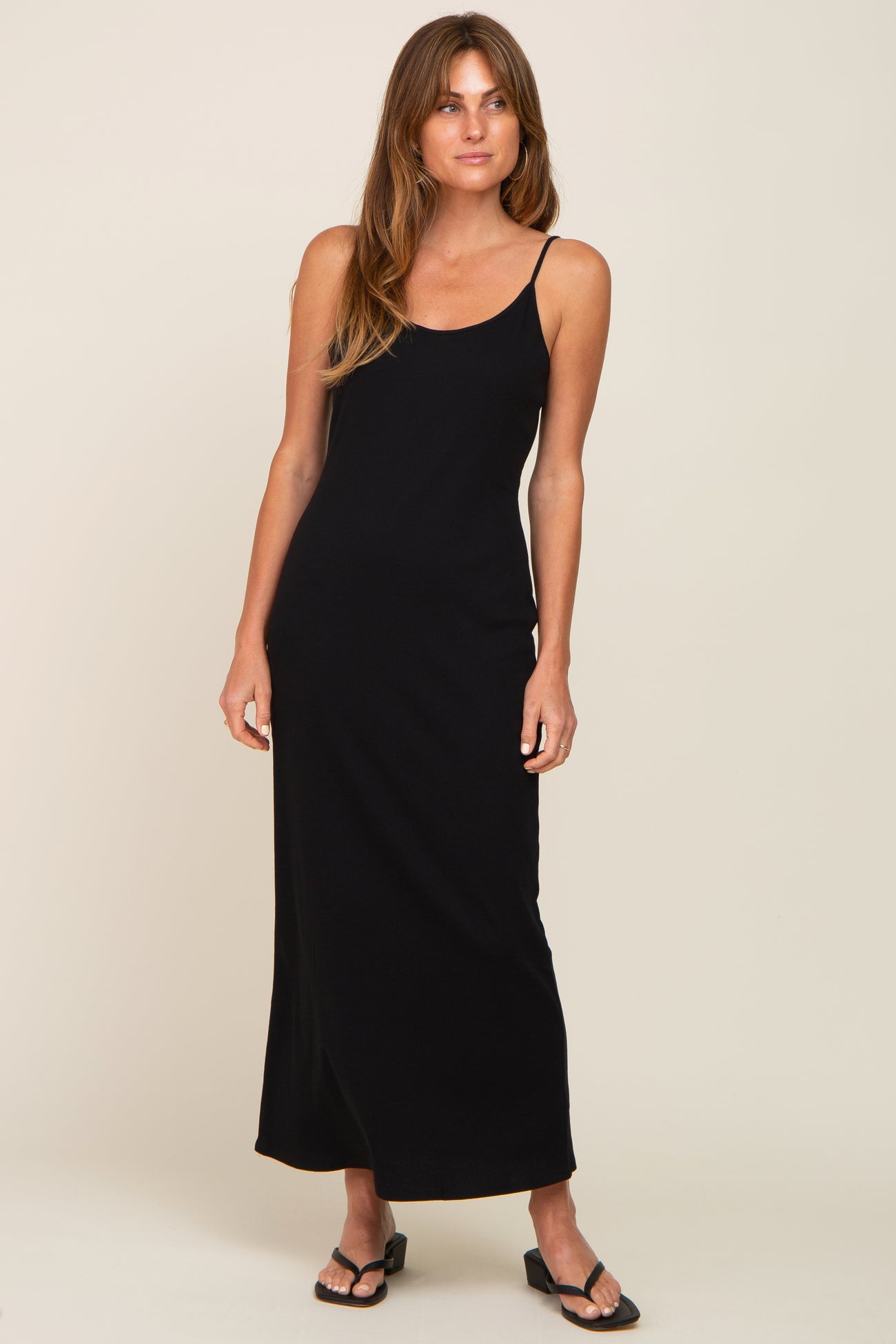 woman wearing a black sleeveless maxi dress with a fitted silhouette and side slit