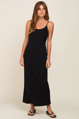 woman wearing a black sleeveless maxi dress with a fitted silhouette and side slit