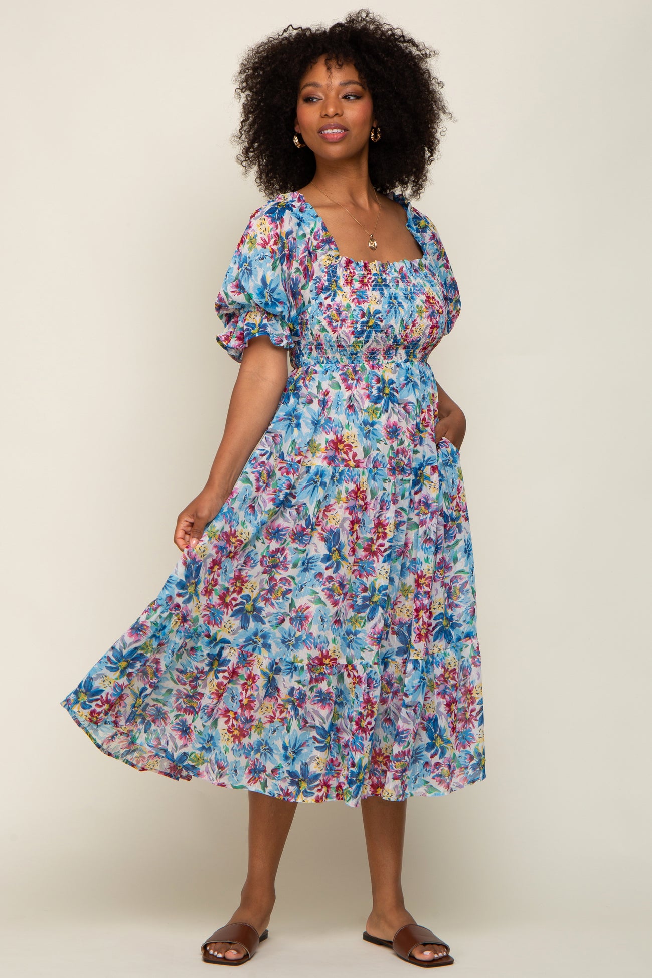 woman wearing a floral long sleeve maxi dress with a square neckline and puff sleeves