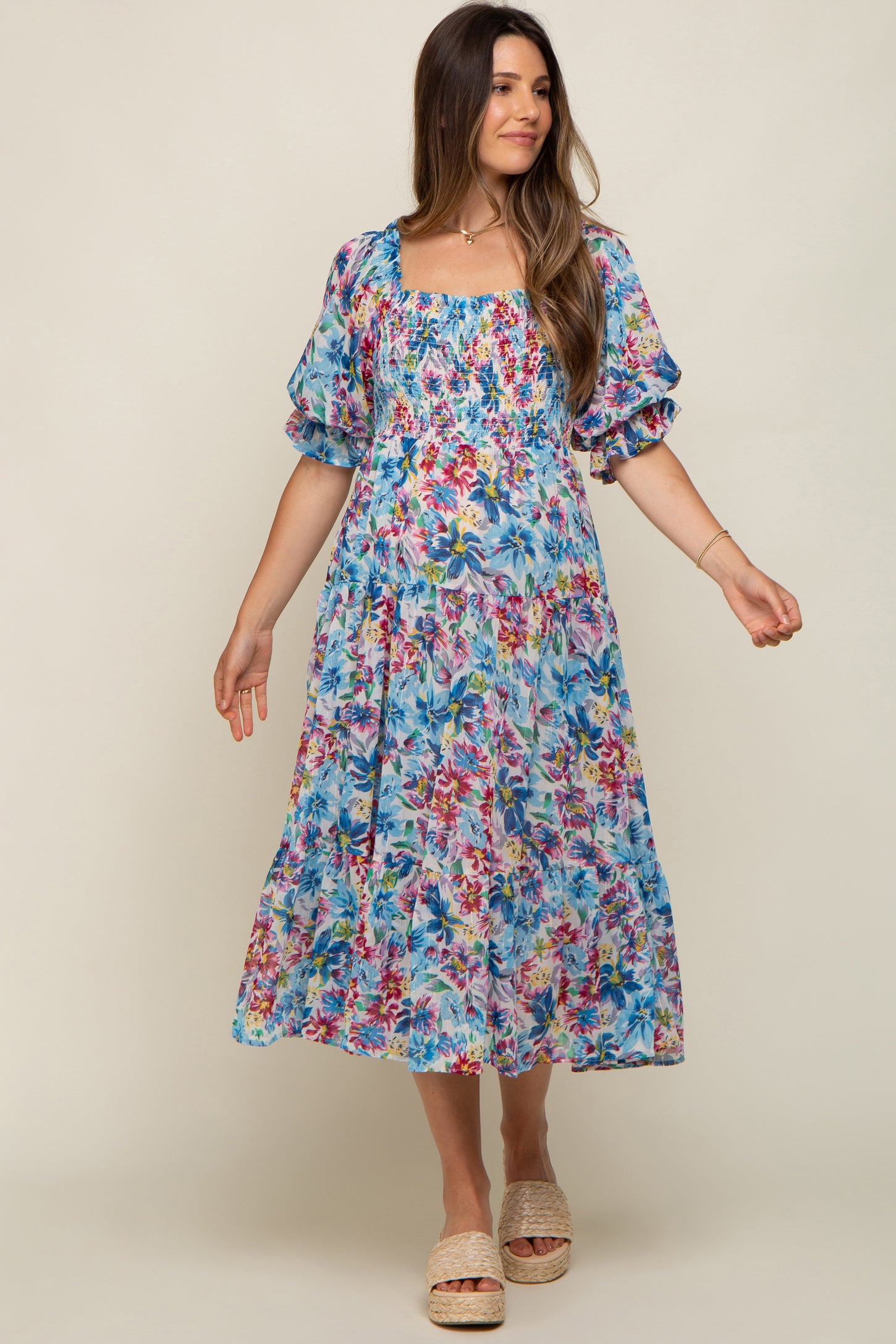 woman wearing a floral patterned maternity dress with puffed sleeves and a square neckline