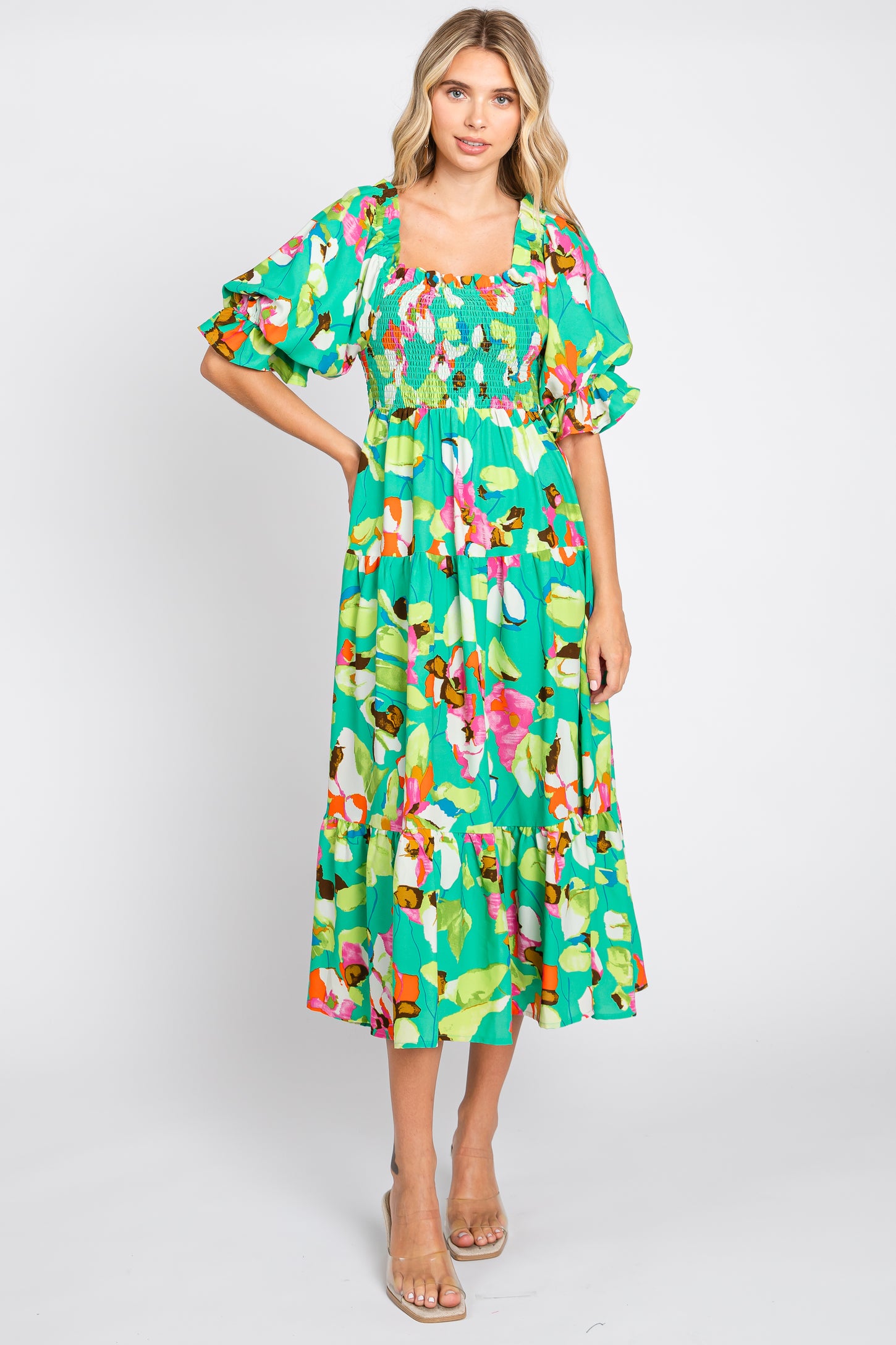 woman wearing a green floral mid-length dress with puff sleeves and a smocked bodice