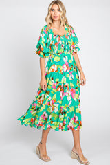 woman wearing a green floral midi dress with puff sleeves and smocked bodice