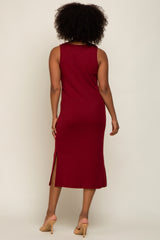 woman wearing a burgundy ribbed midi dress with side slits and a round neckline, shown from the back