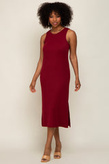 woman wearing a burgundy sleeveless ribbed midi dress with side slits and tan heeled sandals