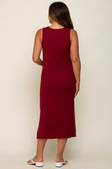 woman wearing a burgundy maternity midi dress with a sleeveless design, seen from the back