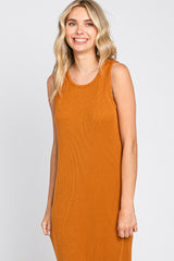 smiling woman wearing a sleeveless burnt orange ribbed knit midi dress against a white background