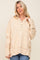 woman wearing a cream oversized henley sweatshirt with buttons and ribbed cuffs