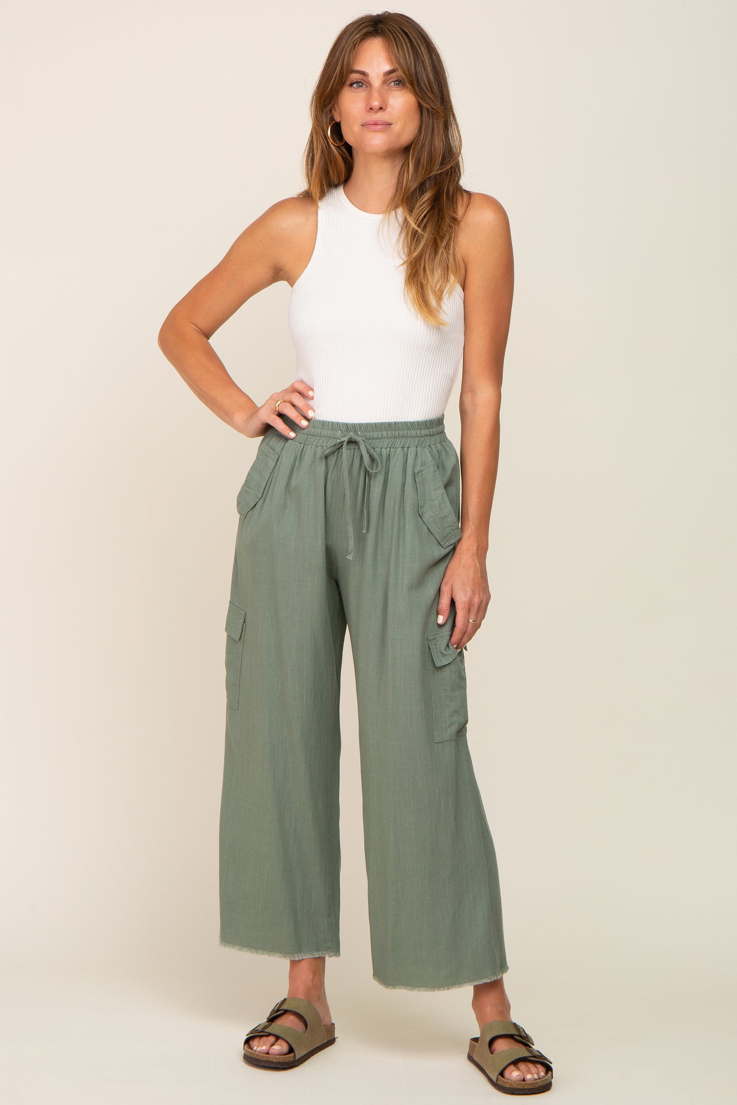 woman wearing white ribbed tank top and olive green wide leg cargo pants with sandals