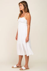woman wearing a white smocked midi dress with spaghetti straps and white slide sandals