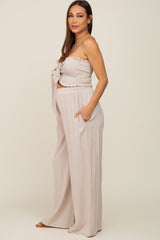 woman wearing beige smocked tube top and matching wide leg linen pants set
