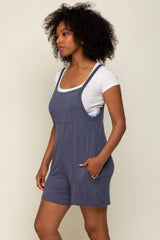 woman wearing a navy blue romper with a pocket and layered over a white t-shirt